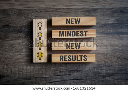 Wooden pieces on a wooden background showing the words new mindset and new results Royalty-Free Stock Photo #1601321614