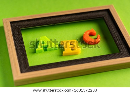 ABC and empty photo frame against green background
