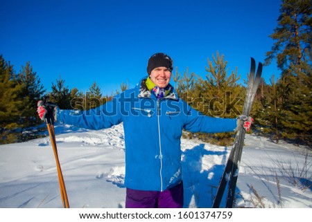 handsome man with skis in the winter forest