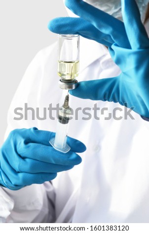 Doctor, nurse or scientist hand in blue nitrile gloves holding flu, measles, coronavirus vaccine shot for baby and adult vaccination, medicine and drug concept.
