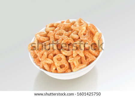 Fried and Spicy ABCD, Alphabet Snacks or Fryums (Snacks Pellets) served in a white bowl. selective focus - Image Royalty-Free Stock Photo #1601425750