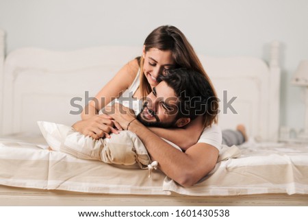 Young playful couple having fun in the bed Royalty-Free Stock Photo #1601430538