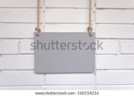 poster hanging on a rope and brick wall 