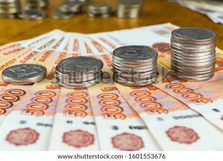 Money on a wooden surface. Russian rubles coins and bills