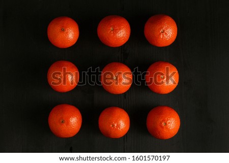 Several mandarins on a wooden black background. Desktop or screen wallpaper,
