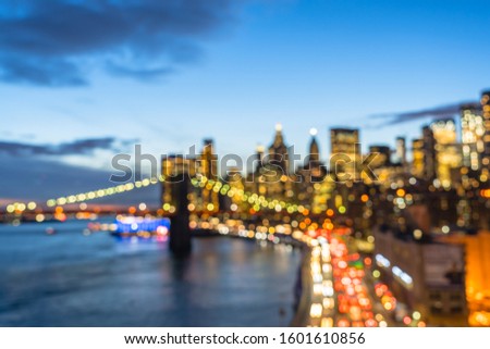 Blur background of New York City Skyline aerial view from Manhattan Bridge with skyscrapers at dusk. Financial District of NYC with traffic light trails on FDR Drive