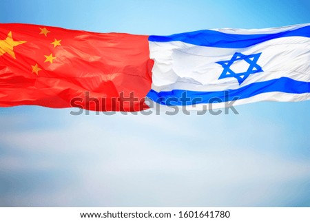 Chinese and Israeli flags amid blue skies