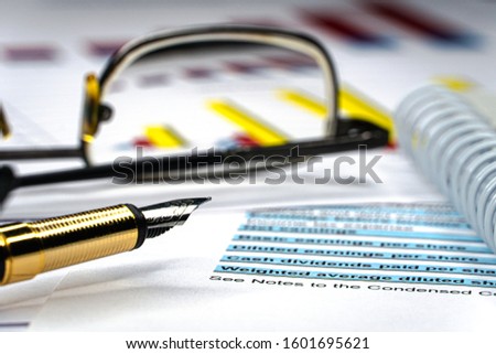 Financial income statement with glasses and fountain pen. Balance tax and investment portfolio