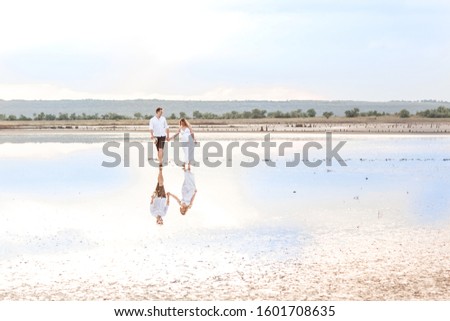 Young couple on a barren landscape.Lovers in the drought at sunrise.
