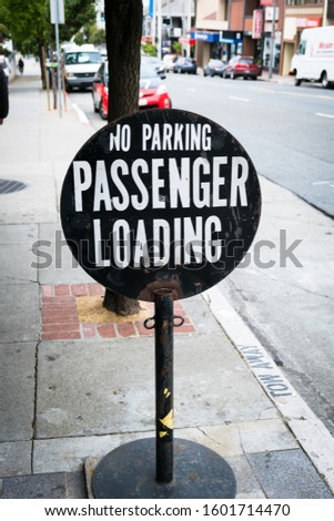 No Parking - Passenger Loading Street Sign on side of street in busy downtown San Francisco California