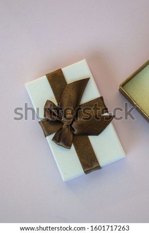 Close-up of wrapped with ribbon, present, gift for the holidays, purple background