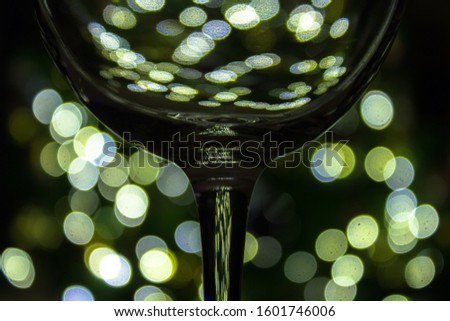 Beautiful clean wine glass with blurred christmas tree lights in the background