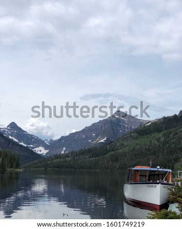 Boat on water in Glacier national park, Montana. Mountains in background.