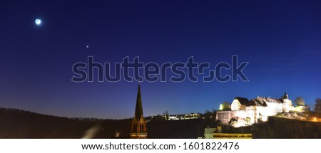 Moon and Venus planet over the church and castle in the night sky.