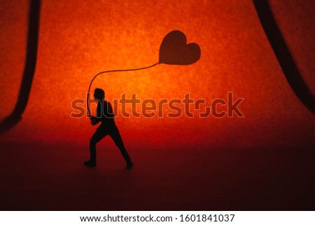 A man walking and holding a heart shaped ball on valentines day