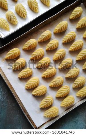 Unbaked Pinneapple tart or Nastar Cookies on the tray. They are ready to bake before brushing process with egg jellow on topped. Made from flour, pinneapple jam, sugar, egg, butter and milk.