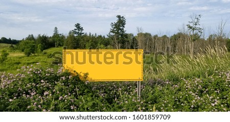 yellow and black sign with no text, forest in the background