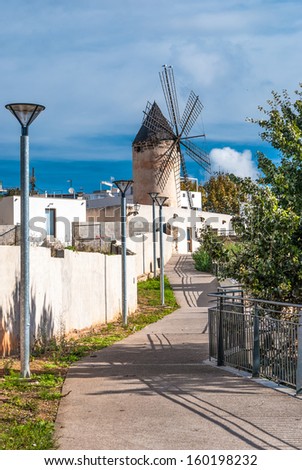 The picture shows a traditional windmill on the streets of Palma de Majorca, Spain.