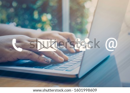 Contact us or Customer support hotline people connect. Businessman using a laptop with the (email, call phone, mail) icons. Royalty-Free Stock Photo #1601998609