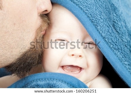Father kissing his smiling baby girl