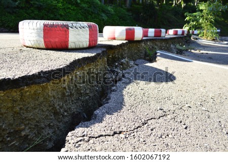 Red and white wheels are Hazardous warning symbol of  road Concrete surface collapsed. Oct 12,19 at Mae Hongsorn, Thailand