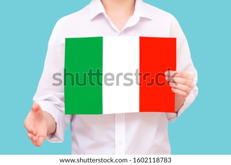 man with the flag of Italy in hand. On a blue isolated background. Unknown person. He reaches out for agreement.