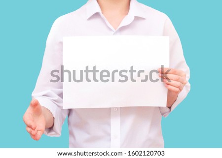 Isolated man with a white sheet of paper in hands, for your text, mockup. Unknown person. He reaches out for agreement.