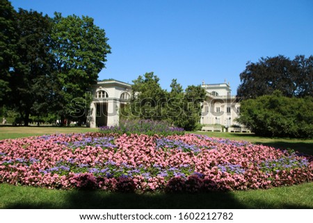 The picture from the Łazienki Park (Spa park) in Warsaw in Poland. Garden full of blooms by one of the houses. 