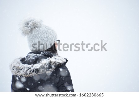 Unknown woman having a walk in the snow on a cold winter day