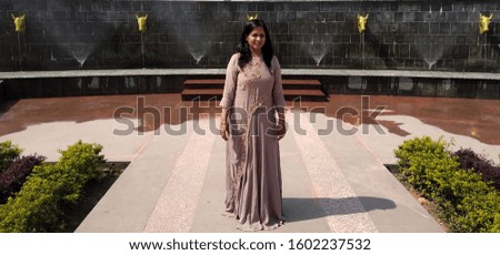 A beautiful girl standing in front of the fountain.