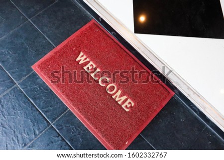 Welcome red mat outside the of door.