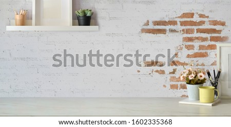 Top view of comfortable vintage workplace with office supplies and copy space on white table and brick wall background