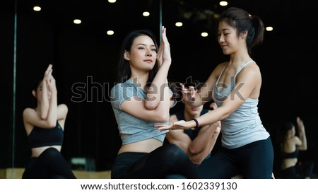 Group of Asian women are doing yoga classes in the gym, wearing sportswear, and workout helps to have a healthy body, a good shape, relaxed muscles and a toned body. sports and healthcare concept Royalty-Free Stock Photo #1602339130