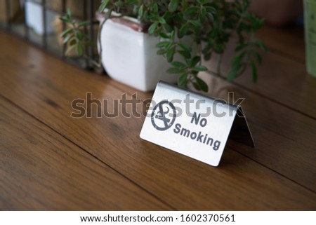 No smoking metal sign on the wooden table