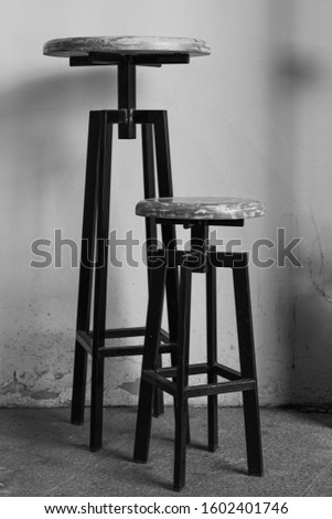 an old bar stool on a beige background. bar stools in the yard. Monochrome photography.