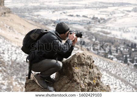 A photographer taking a picture of a winter landscape