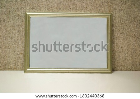 blank frame on a grey background and wite botton