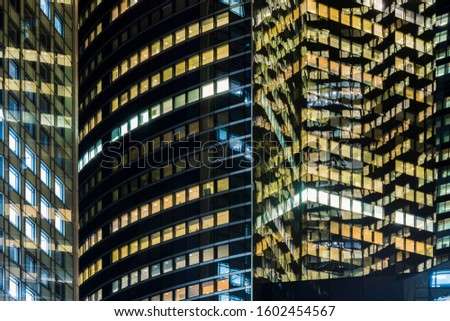 Lights and reflections of windows of some modern business buildings at night. Real state of business