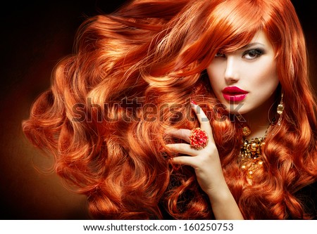 Long Curly Red Hair. Fashion Woman Portrait. Beauty Model Girl with Luxurious Hair, Make up and Accessories. Hairstyle. Wavy Hair Extensions Concept. Holiday Makeup. Smoky eyes and Red lipstick