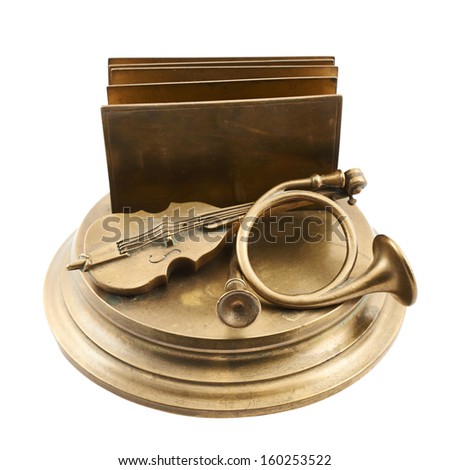 Paper and card metal holder as a cello, trombone and folder composition over podium, isolated over white background