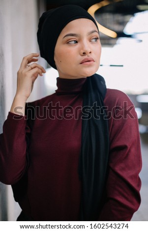 A fashion portrait of a young and attractive Muslim  woman in the nice garden. isolated with blurry backgrounds and grain film