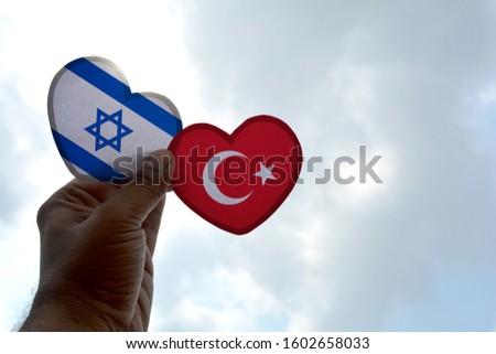 Hand holds a heart Shape Israel and Turkey flag, love between two countries