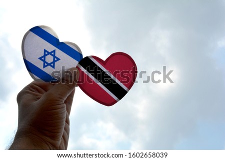 Hand holds a heart Shape Israel and Trinidad and Tobago flag, love between two countries