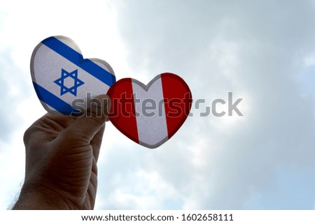 Hand holds a heart Shape Israel and Peru flag, love between two countries