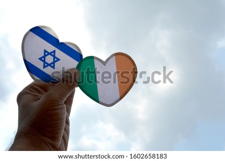 Hand holds a heart Shape Israel and Ireland flag, love between two countries