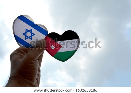 Hand holds a heart Shape Israel and Jordan flag, love between two countries