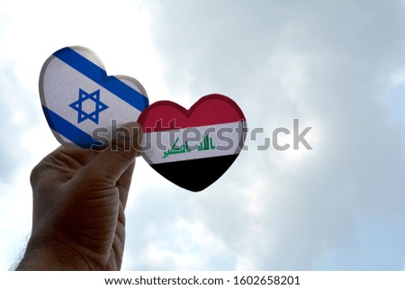 Hand holds a heart Shape Israel and Iraq flag, love between two countries