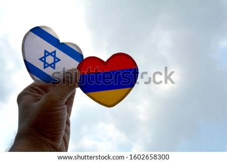 Hand holds a heart Shape Israel and Armenia flag, love between two countries