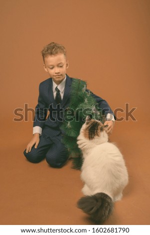 Young boy as businessman against brown background