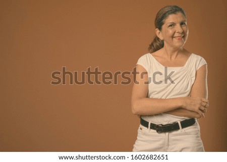 Mature beautiful businesswoman against gray background in black and white